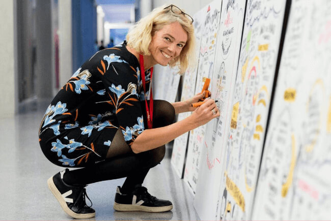 A picture of Drawify Founder Axelle Vanquaillie doing graphic recording at a client event